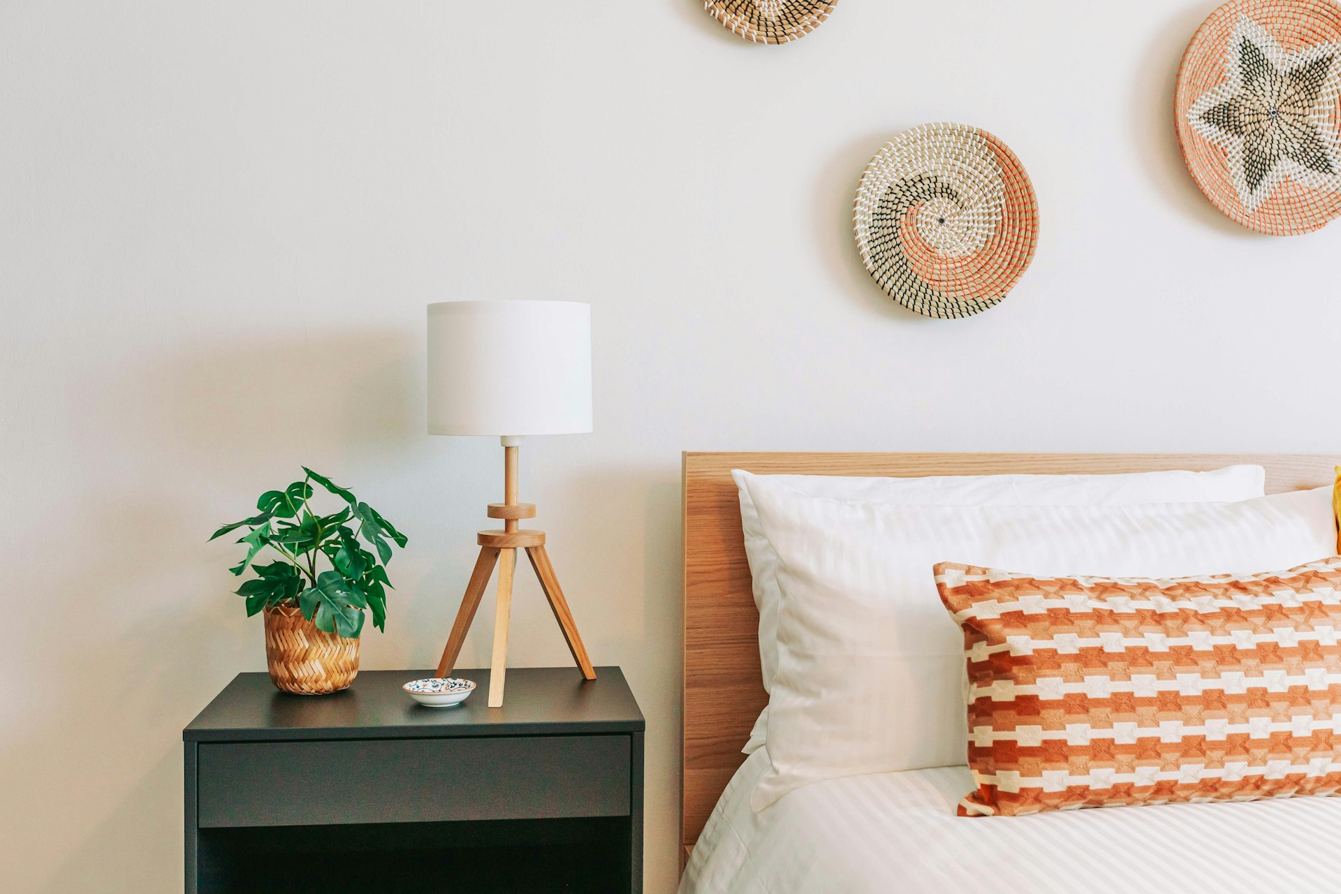 a bed room with a neatly made bed and a night stand
